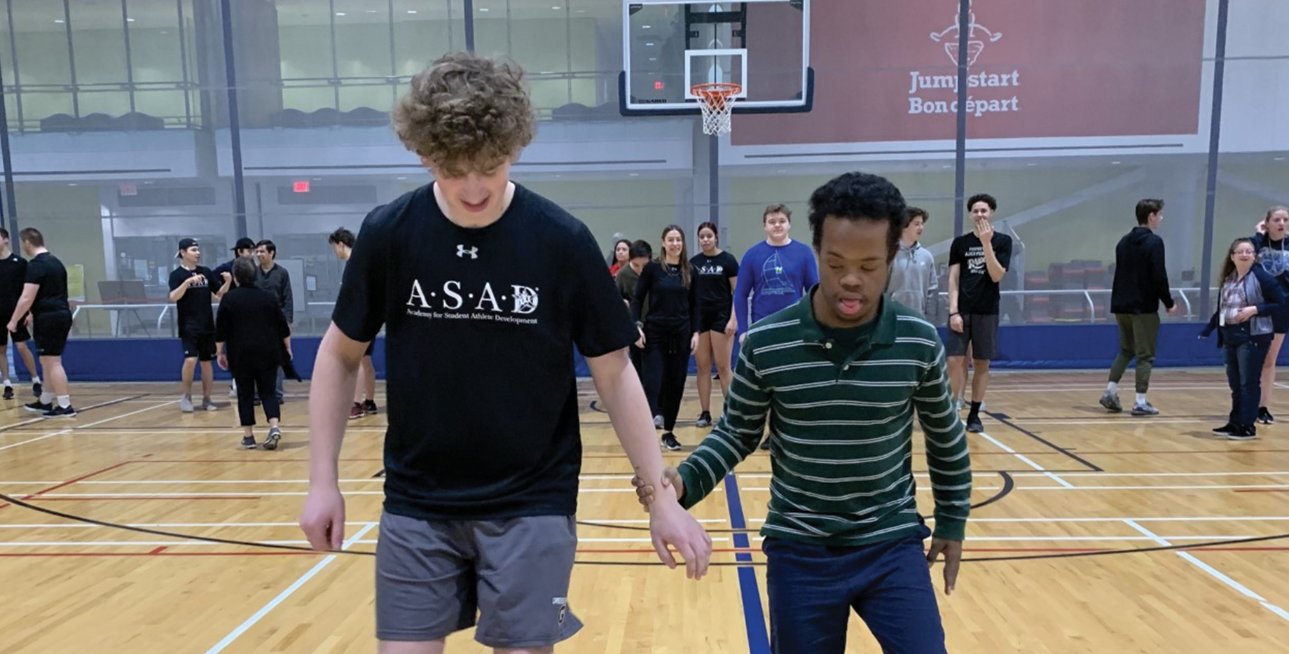 A vast group of Abilities Centre participants of different age groups experience an athletic activity within the Fieldhouse