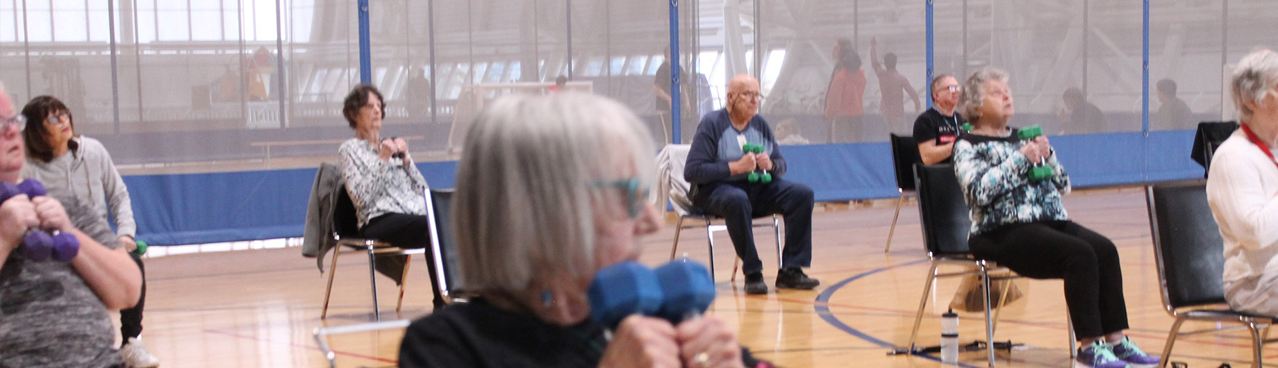 Members realizing the value of inclusivity and accessibility through the membership assistance program in an active class on the court in the Fieldhouse