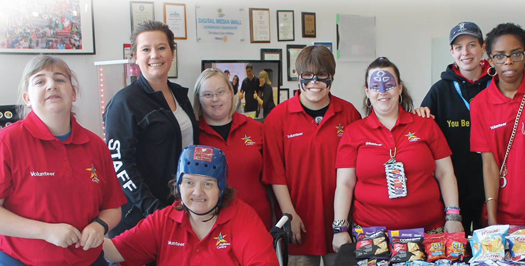 Abilities Centre coordinator poses for picture in Atrium with volunteer participants