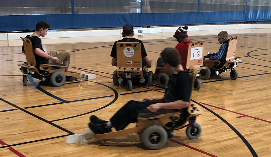 five youths playing volt hokcey chairs on the AC court